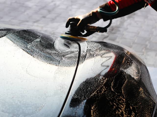 Detailing professional washing and rinsing a vehicle exterior
